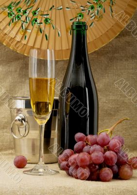 Champagne bottle, bucket, goblet and grapes