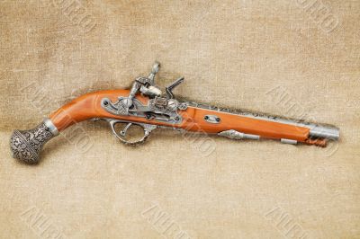 Ancient pistol on background canvas