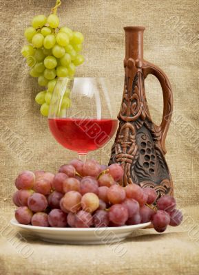 Ceramic bottle, grapes and red wine