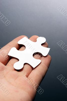 Hand holding a puzzle piece