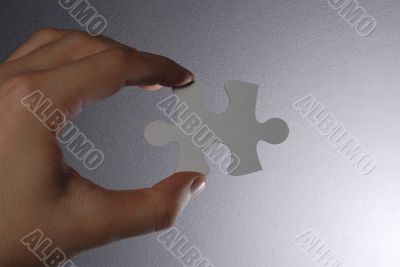 Hand holding a puzzle piece