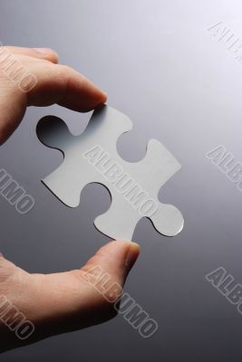 Hand holding a puzzle piece