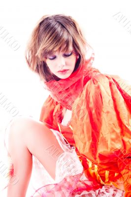 Cute teenage girl in an orange fancy dress thinking