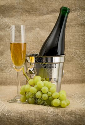 Champagne bottle, bucket, goblet and grapes