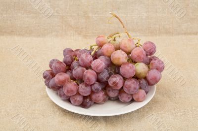 Grape on plate on textile background Grape on plate on textile background