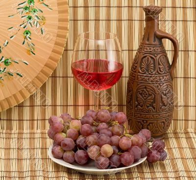 Bottle, bucket, goblet and grapes