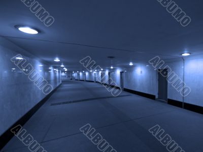 Dark concrete corridor with a closed doors