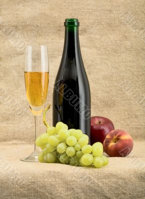 Champagne bottle, goblet, grapes, apple and peach