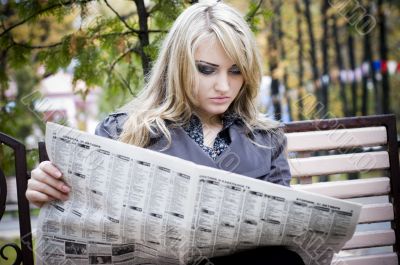 Young woman reading a newspaper