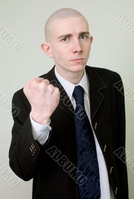 Man in a suit threatens with a fist