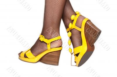 Feminine legs, yellow sandals, accessor