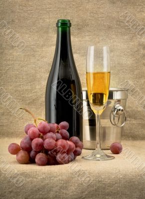 Champagine bottle, grape and goblet on canvas background