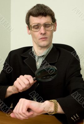 Person view a watch through a magnifier