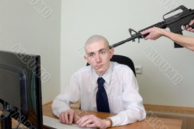 Man at office with a rifle near a head