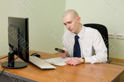 Businessman with a magnifier on a workplace