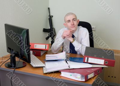 Self-satisfied worker of office armed with a rifle