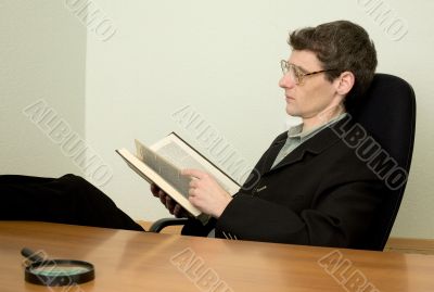 Guy in eyeglasses reads the book
