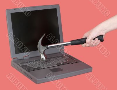 Laptop and hand with hammer