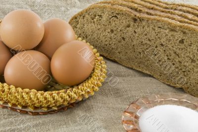 Many fresh rural eggs lying in a wattled small basket near to fr