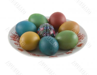 The easter decorated eggs lying in white porcelain plate with a