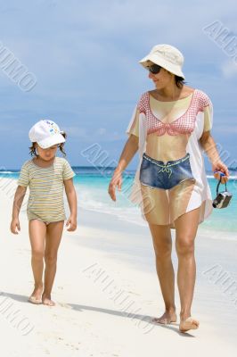 Daughter and mother walking on the beach