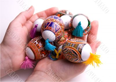 Colorful Easter eggs in palms, isolated.