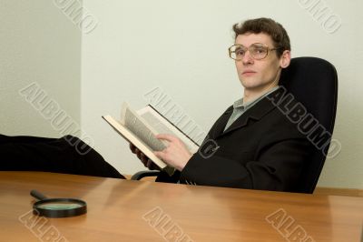 Guy in eyeglasses reads the book