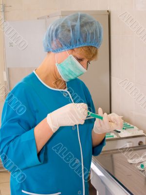The nurse filling a syringe by a medicine.