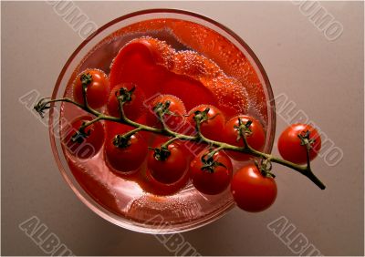 Bright red tomatoes in a bowl with water.