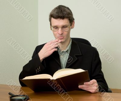 Guy in eyegasses reads the book
