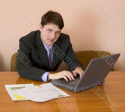 Businessman sits at table with the laptop