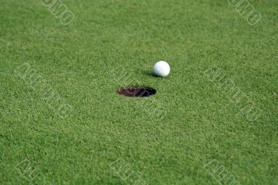 Golfball in front of the hole