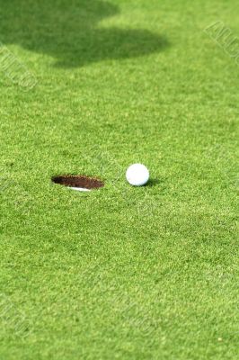 Golf ball in front of the hole Golf ball in front of the hole