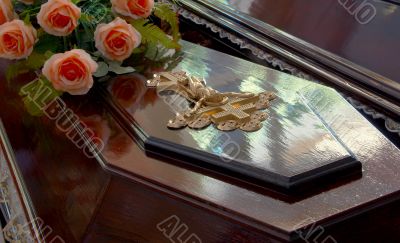 golden Jesus crucifix on dark wooden coffin top