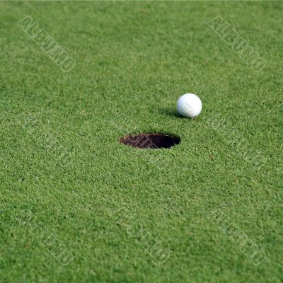 Golfball in front of the hole