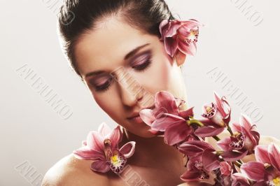 Beautiful young woman with orchid flowers