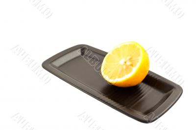 half of lemon on a black square plate