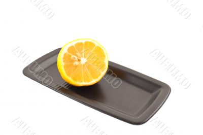half of lemon on a black square plate