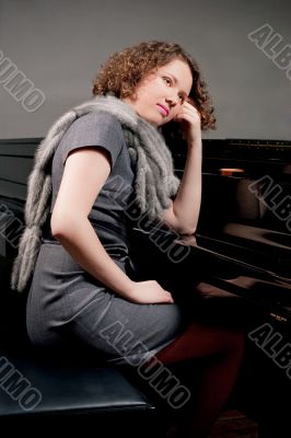 pretty young girl near piano thinking smiling