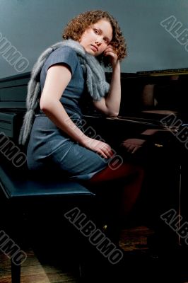 pretty young girl near piano thinking