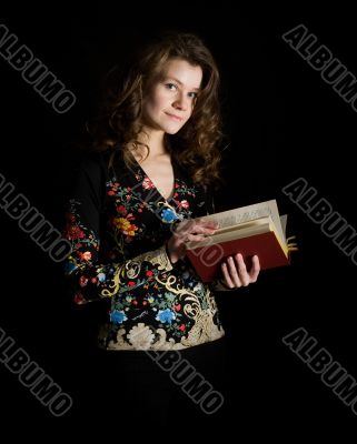 Girl with book on black background