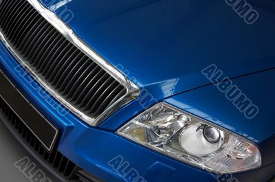 headlight and grate of radiator on a dark blue car