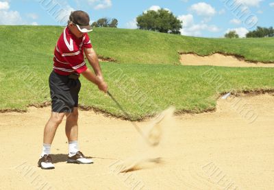 Senior golfer playing golf from sand bunker