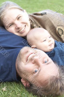 Happy family lying on the grass