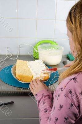 girl is decorating a cake with whipped cream