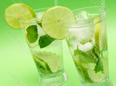 Two mojito cocktails on green background Two mojito cocktails on green background