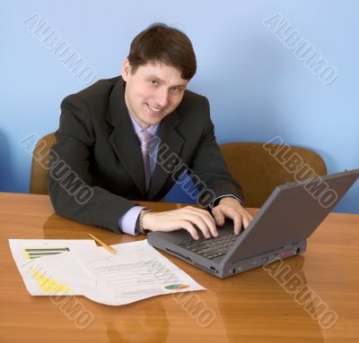 Businessman sits at table with the laptop Businessman sits at table with the laptop