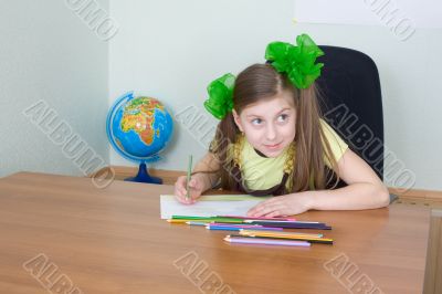 Girl sitting at a table with pencils Girl sitting at a table with pencils