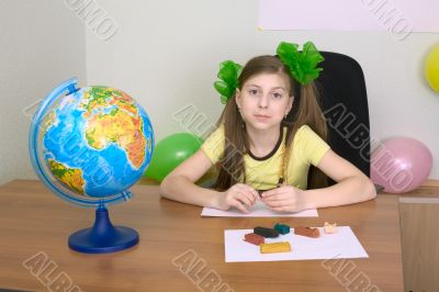 Girl sitting at a table with plasticine Girl sitting at a table with plasticine