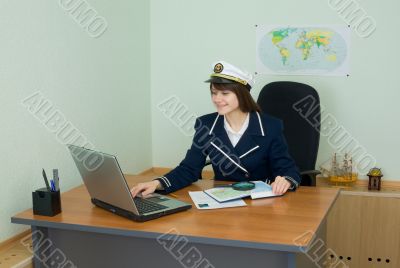 Portrait of the girl in a sea uniform at a table